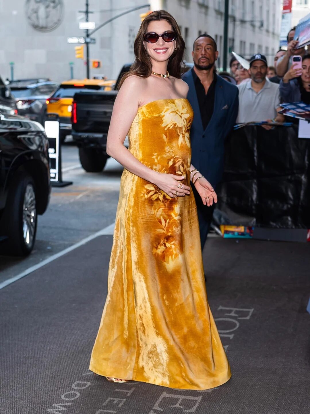 Anne Hathaway con vestido dorado de terciopelo floral de Lela Rose