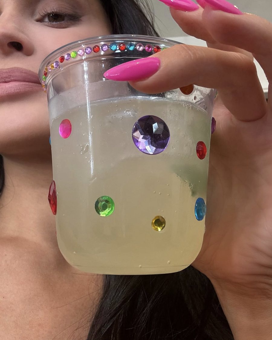 Vaso plástico con piedras de colores pegadas, sostenido en la mano