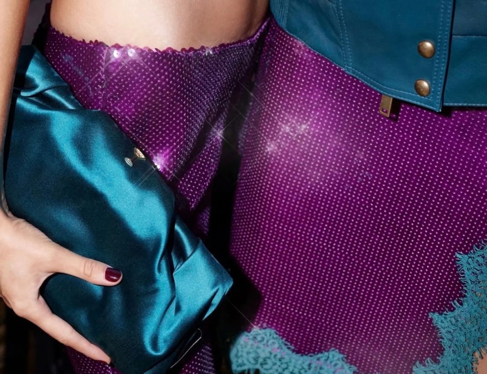 Detalle: falda de lentejuelas moradas con borde de encaje turquesa y cartera de raso turquesa