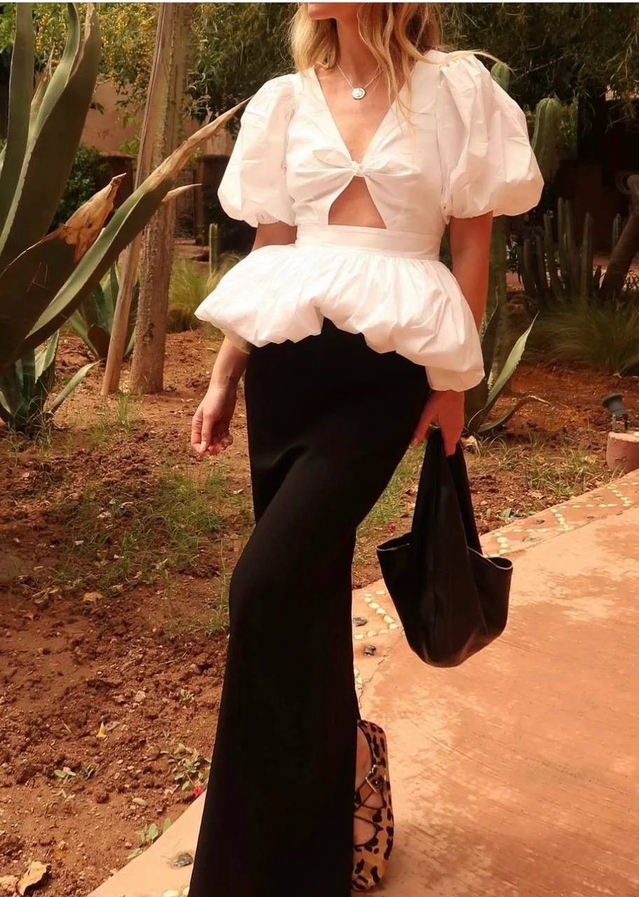 Top blanco escultural con pantalón negro: una pieza protagonista sobre neutros